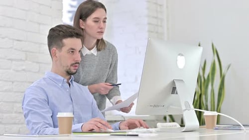 Man and Woman Collaborating on Computer Work