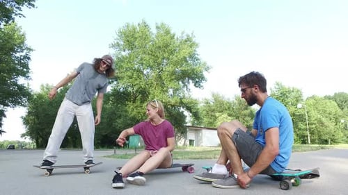 Friends Socializing on Skateboards Outdoors in Daytime