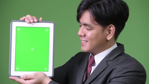 Young Adult Holds Tablet with Chroma Key Screen