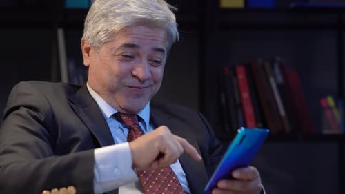 Smiling Businessman Using Smartphone Device in Office