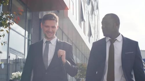 Businessmen Walking and Talking Outside Modern Office