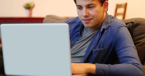Man Using Laptop While Sitting on a Couch