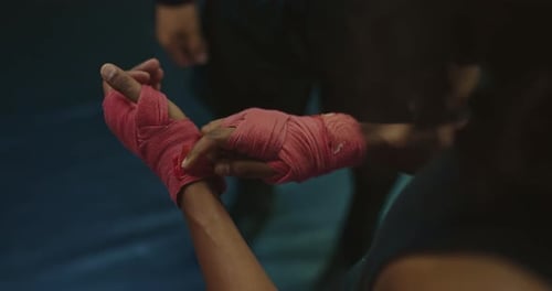 Black Kickboxer is Wrapping His Fists Before Training or Grappling on Ring Closeup View Prores