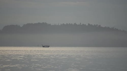 A boat is move at sea with background mountain.