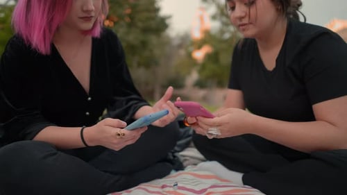 Girls in the Public Park Using Smartphones and Texting on It Close Up View