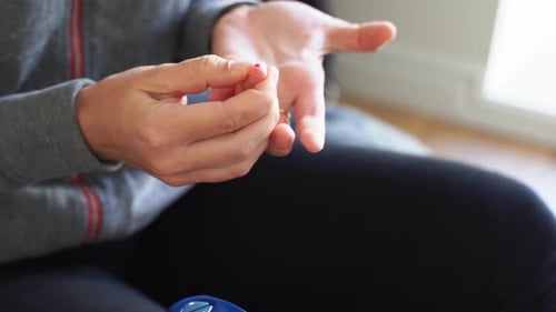 Nahaufnahme der Hände einer jungen Frau mit Glukosemessgerät. Blutuntersuchungen zu Hause. Metabolisches Syndrom