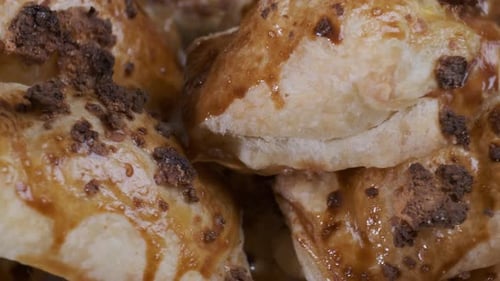 Gebackener Blätterteig mit Toppings. Puffs mit Käse auf weißem Teller, der sich vor der Kamera dreht