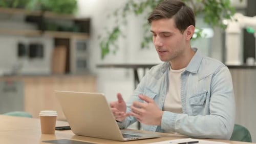 Man Participating in Lively Video Call on Laptop