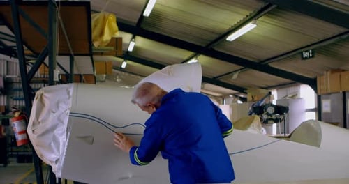 Senior Man Working on a Small Airplane