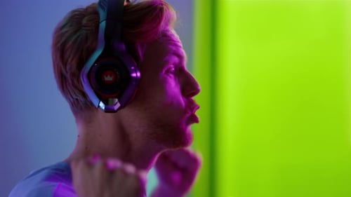 Excited Gamer Celebrating Victory in Front of Green Screen