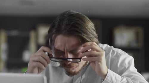 Manager in Glasses Attentively Working on Laptop Computer in the Office