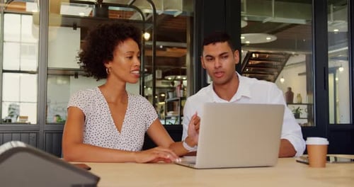 Business people discussing over laptop in modern office 4k