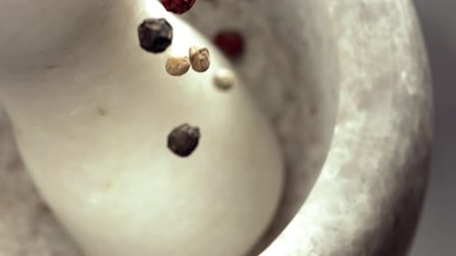 Colorful Peppercorns Filling White Mortar in Slow Motion