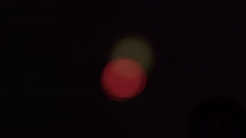 Weite Aufnahme von Bokeh-Mustern, die durch ein unscharfes Feuerwerk in der Ferne erzeugt wurden.