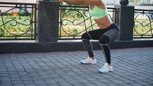 Active woman exercising and stretching in city park