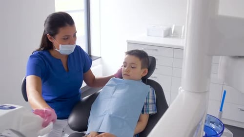Female Dentist with Kid Patient at Dental Clinic
