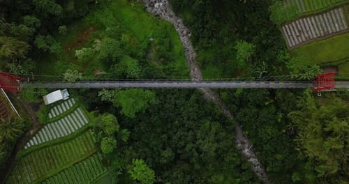 aerial drone view of fly over metal suspension bridge that builds crossing the valley and river with