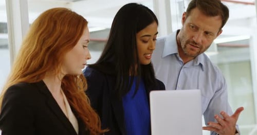 Team Collaborating on Laptop in Modern Workplace
