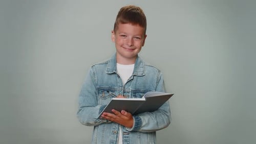 Young Boy Writing in Notebook Indoors