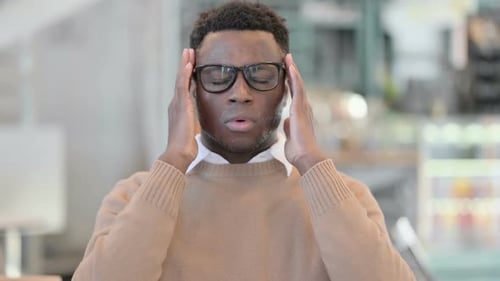 Young Man Massaging Temples Suffering Headache