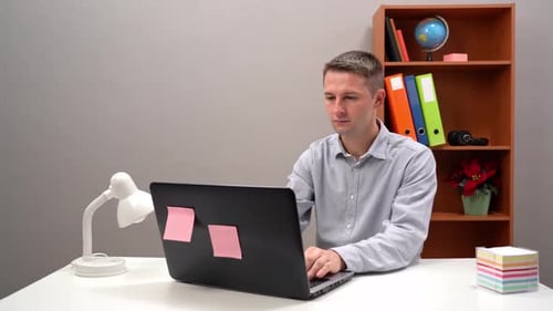 Young Adult Working at a Computer at Desk