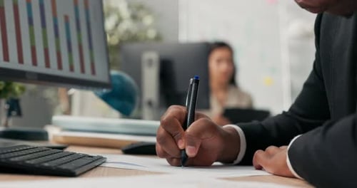 Business Professional Writing at Desk in Office