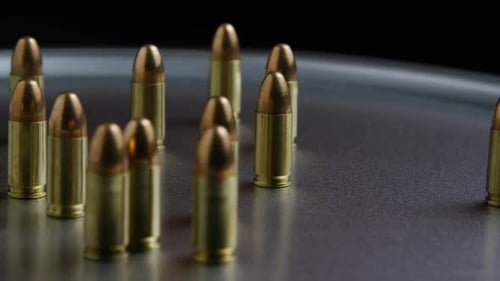 Cinematic rotating shot of bullets on a metallic surface - BULLETS