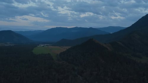 Aerial of majestic mountains in valley of Altai under sunset sky