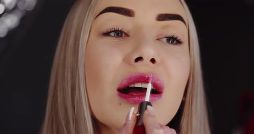 Young Beautiful Girl Paints Lips, Close Up. Makeup
