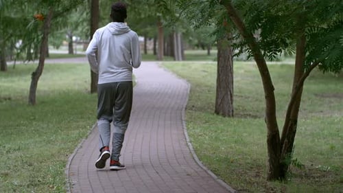 Rear View of African Man Jogging at Summer Day