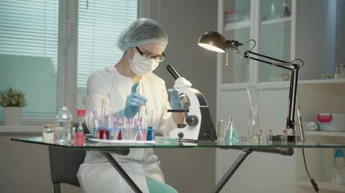 Focused Scientist Using Microscope in Bright Laboratory