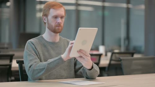 Young Man Using Tablet While Sitting in Office