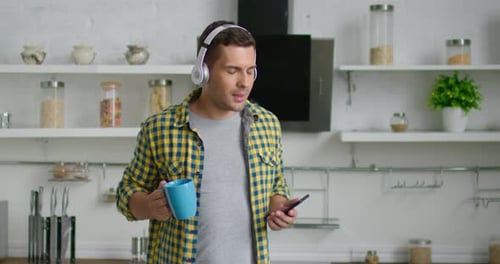 Young Adult Dancing to Music in Kitchen