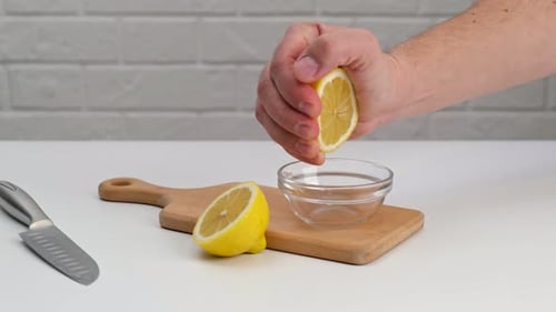 Fresh Lemon Juice Squeezed into Clear Glass Bowl