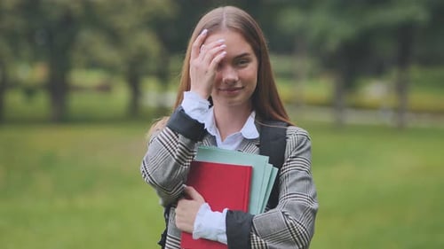 A Smiling Student with Books in the Park