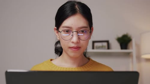 Young Adult Works on Laptop Indoors