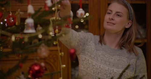 Woman Decorating Christmas Tree with Ornaments