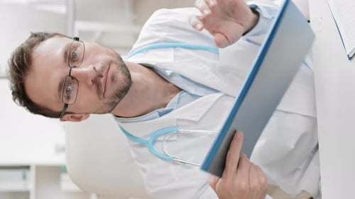 Focused Doctor Reviewing Patient Records in Office