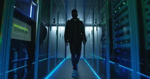 Masked Figure Walks in Dark Server Room