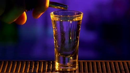 Barkeeper macht weiter, gießt Cocktail mit weißer Alkoholflüssigkeit ein, Schüsse, Zeitlupe