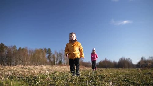 young children playing outdoors and running toward camera