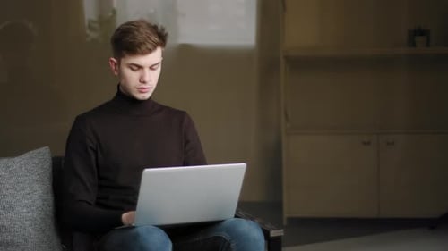 Young Adult Working on Laptop at Home