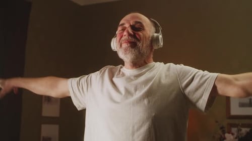 Senior Man Dancing Indoors Wearing Headphones