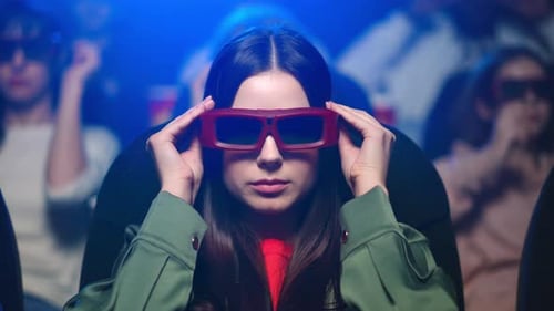 Smiling Woman Enjoying Comedy in Movie Theater. Girl Putting on 3d Glasses