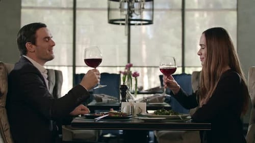 Couple in Love Drinking Red Wine in Restaurant. Man and Woman Dining in Cafe