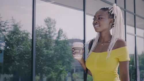 Smiling Woman Walking with Coffee in City