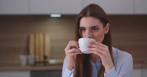 Woman Enjoying Coffee in Kitchen