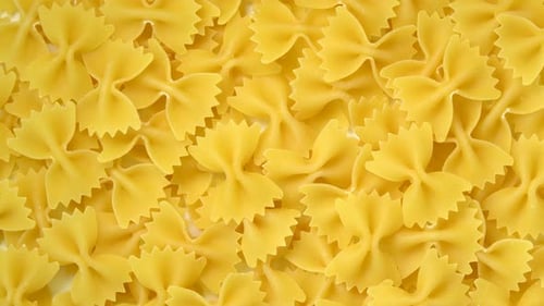 Uncooked farfalle or bow-tie pasta rotating top view