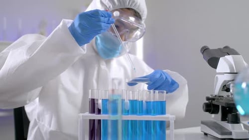 Scientist in Hazmat Suit Drops Liquid Into Test Tube