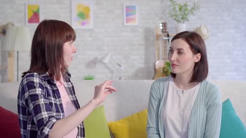 Two Young Women Chatting Casually on Couch